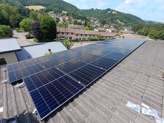 Impianto fotovoltaico su tetto in tegole, con le colline sullo sfondo