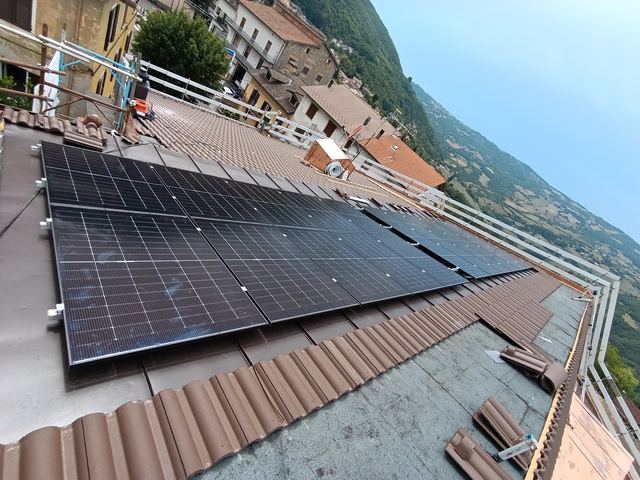 Moduli fotovoltaici in copertura, con vista sul paese e sulla valle