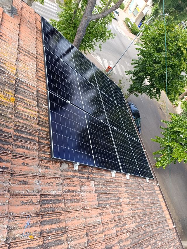 Moduli fotovoltaici sul tetto, sopra un viale alberato