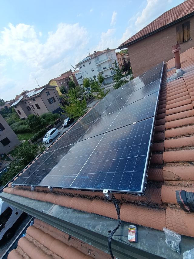 Impianto fotovoltaico su tetto in coppi, con vista sul quartiere
