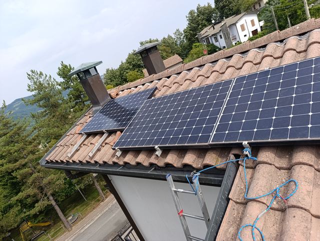 Posa di moduli fotovoltaici su tetto in coppi, con linea vita e scala durante il cantiere