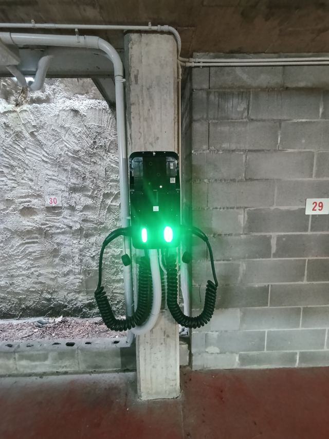Colonnina di ricarica doppia in un garage con posti auto numerati
