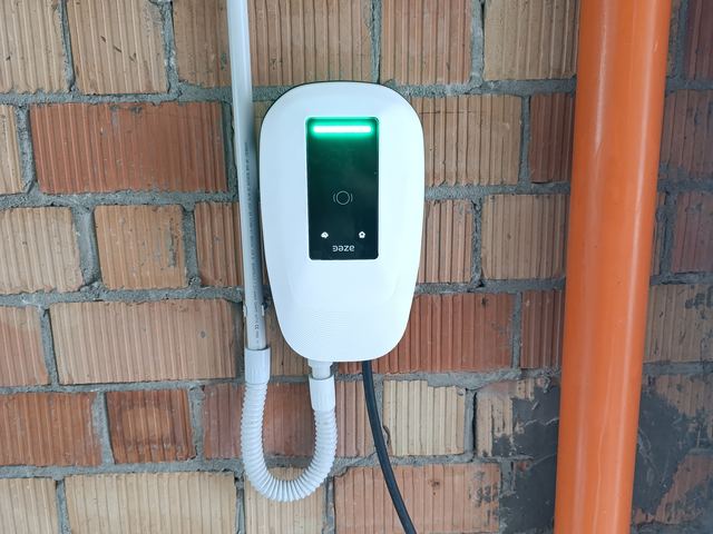 Wallbox DAZE installata su parete in mattoni, accanto al pluviale
